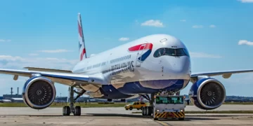 A British Airways crew member activates the emergency slide