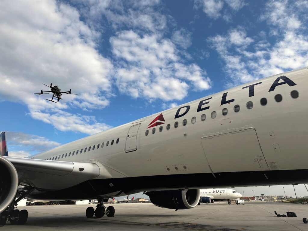 An autonomous drone embarks on a test flight by pilot in the sprawling Delta (DL) maintenance hangar adjacent to Atlanta's bustling runways. 