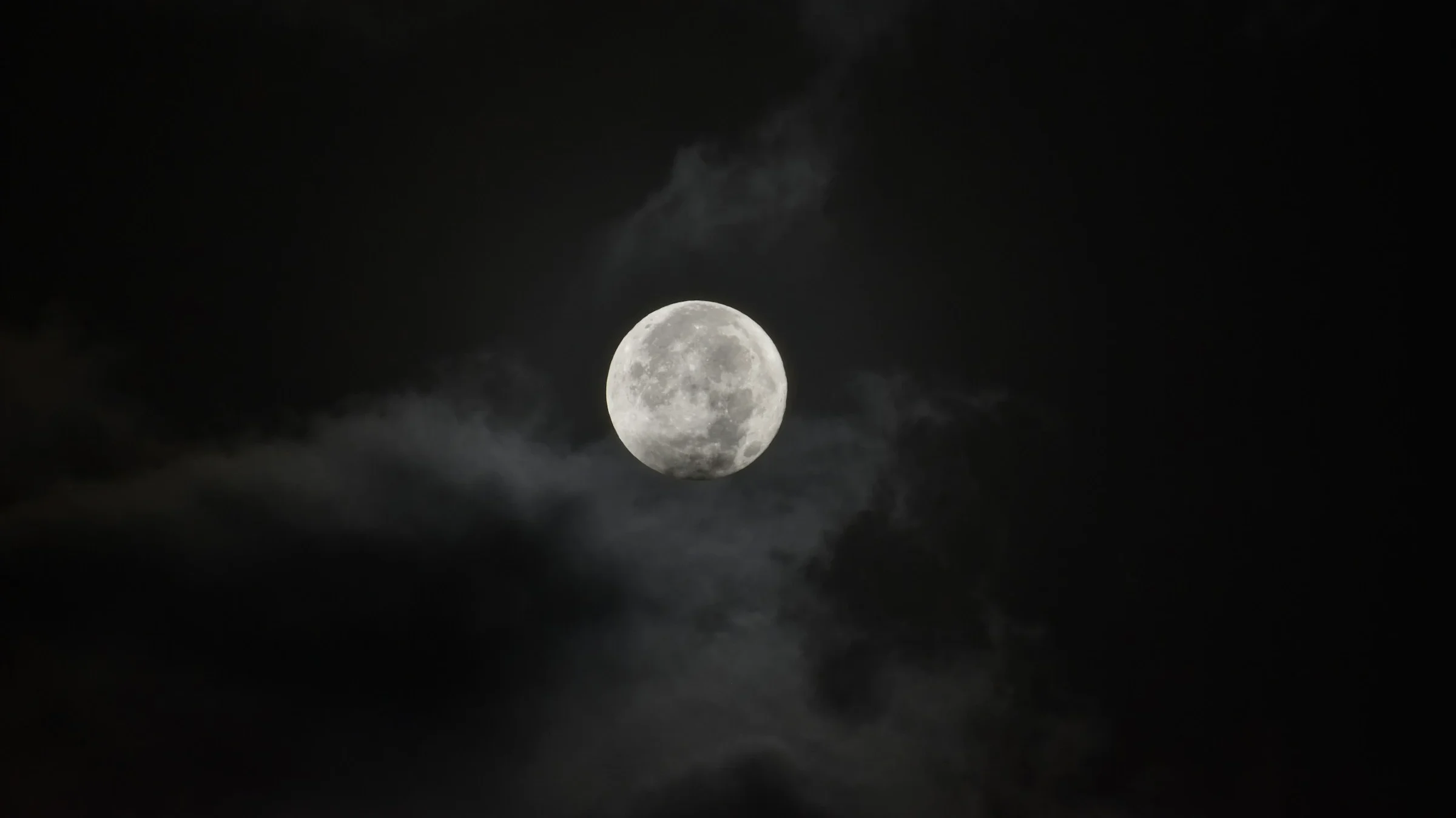 Full Moon in the cloudy sky illuminating the clouds