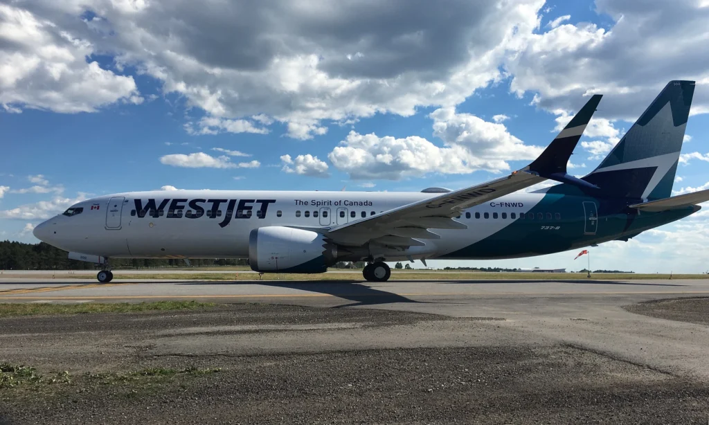 WestJet Boeing 737 MAX 8 aircraft parked at an airport before departure.