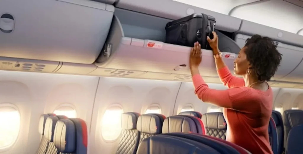Passenger putting her luggage in an overhead bin